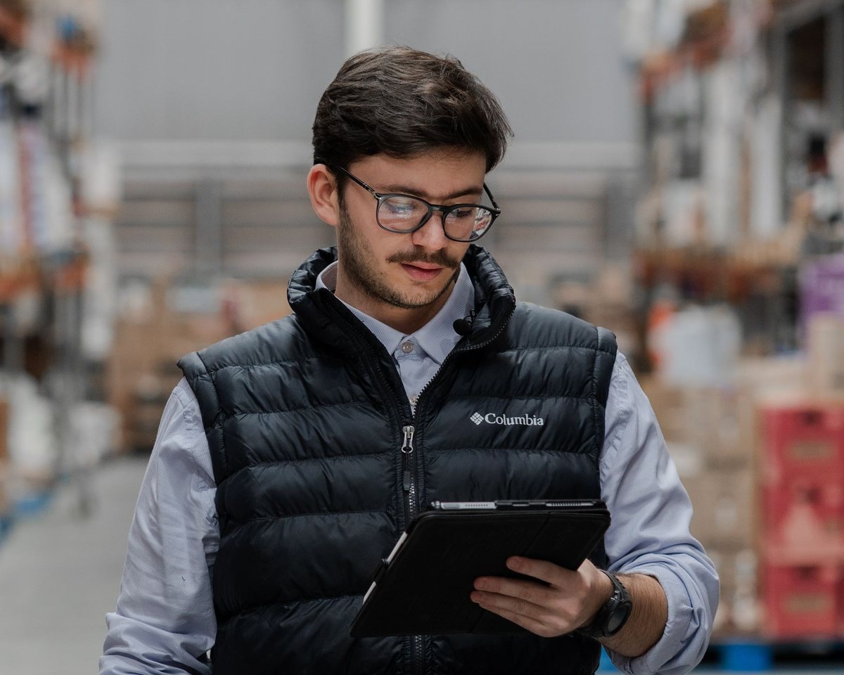 Warehouse lead checking cold-storage zone readings on a tablet